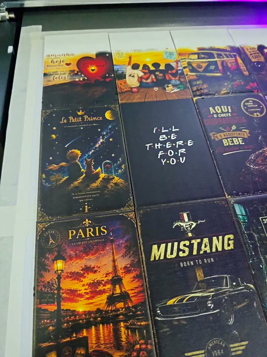 Coleção de placas decorativas com artes de Paris, Mustang e frases, lado a lado na mesa da impressora